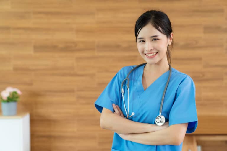 Young Asia pretty doctor standing at nursing home with smile and