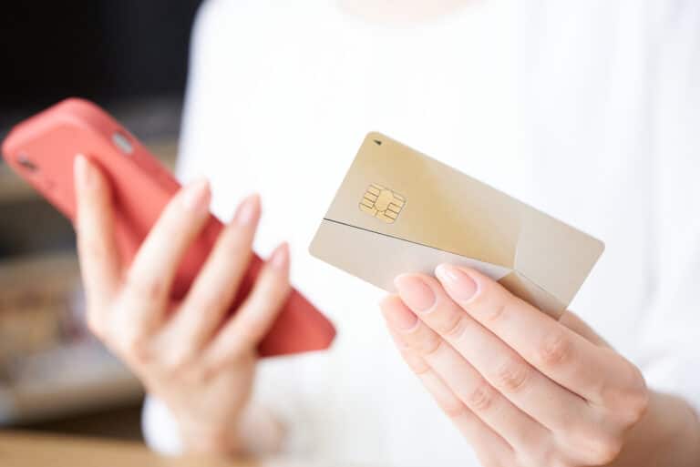 クレジットカードとスマートフォンを持つ女性