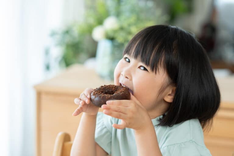 チョコレートドーナツを食べる子供