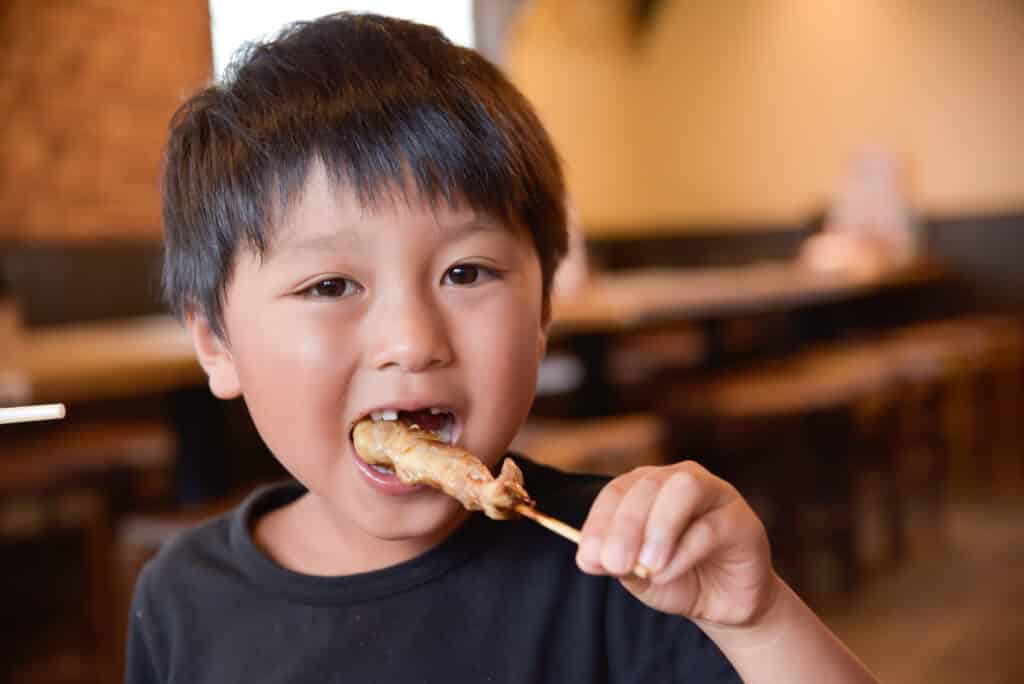 焼き鳥を食べる子供