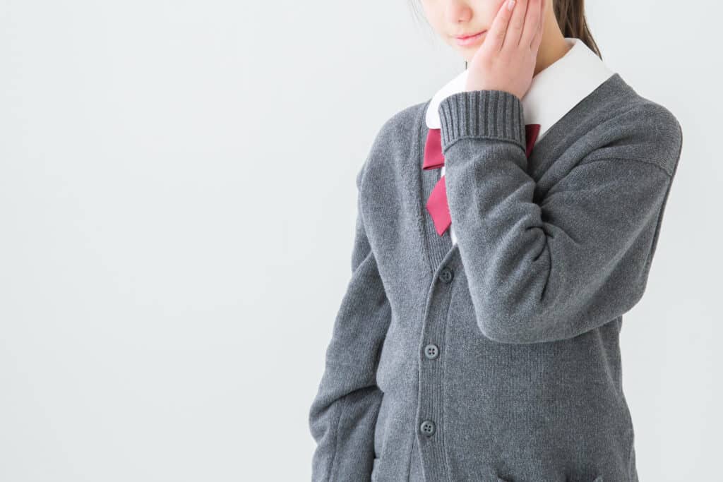 頬を抑える女子学生