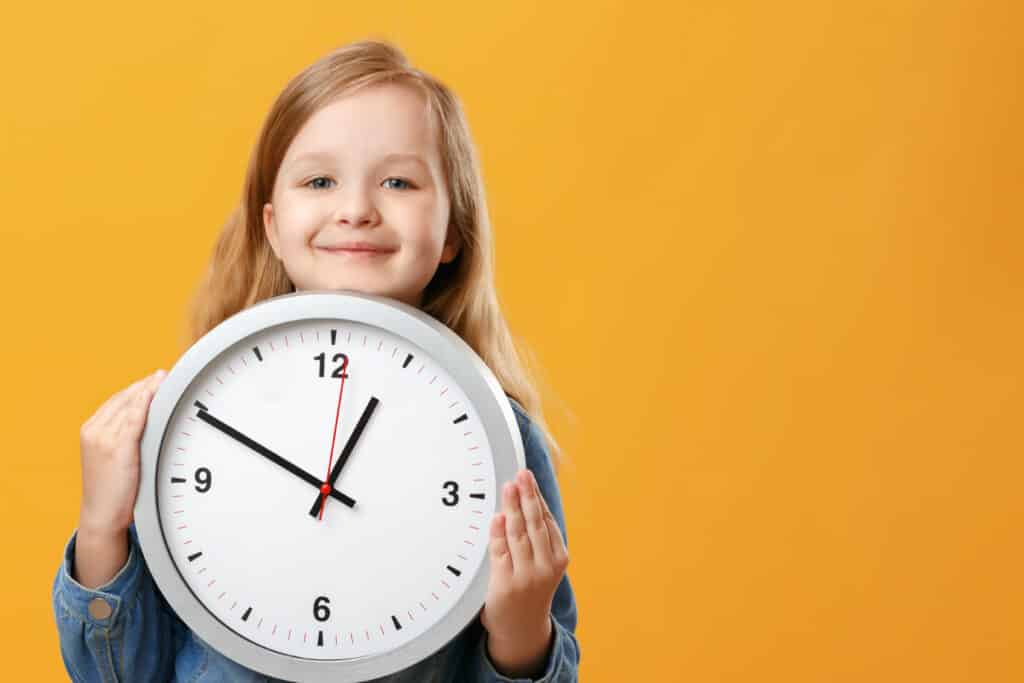 A cute little girl holding a big clock_279592410